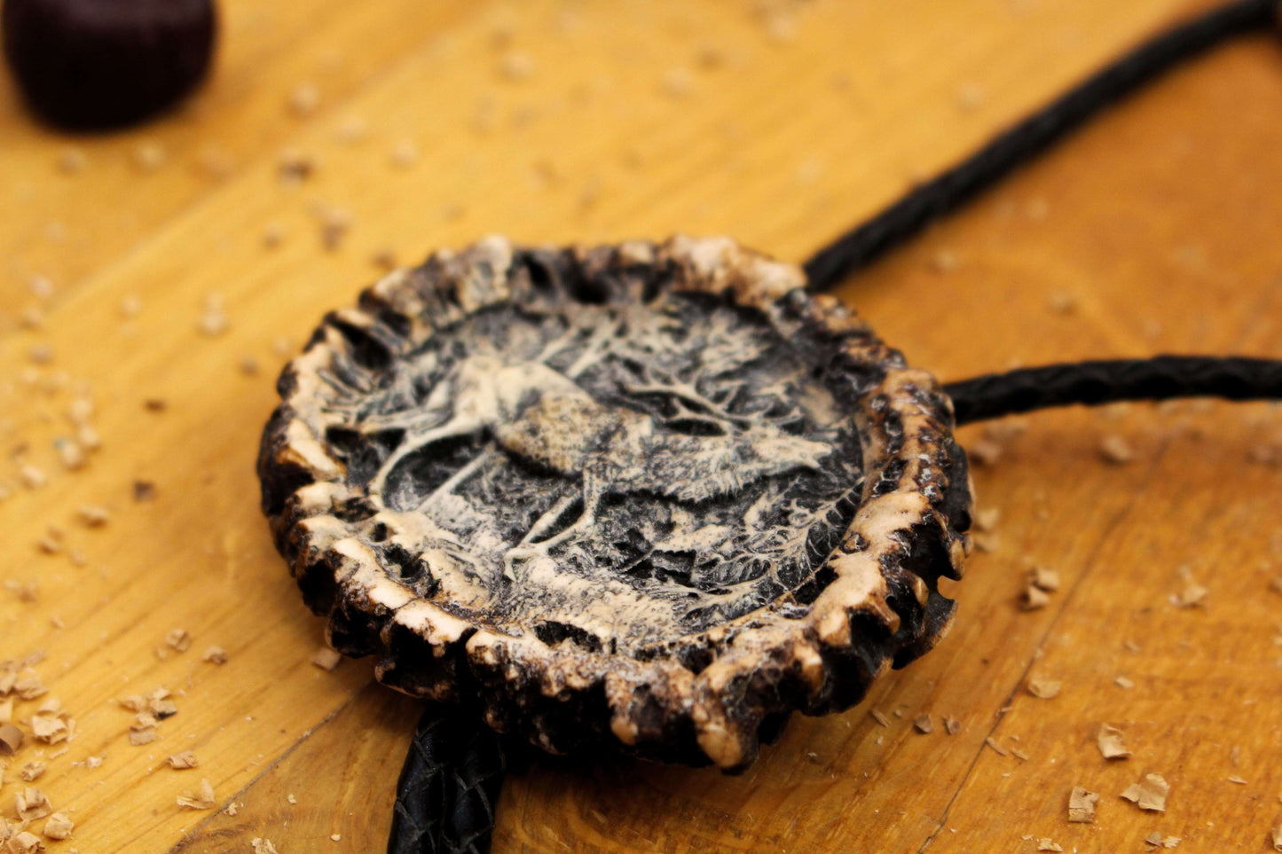 Side shot of Bolo Tie with Deer Roaring design and leather cord