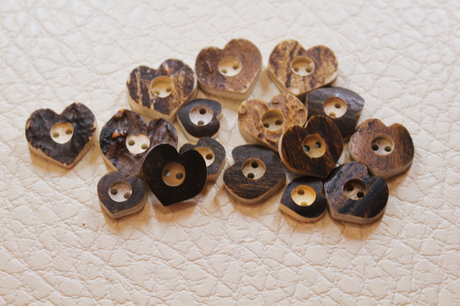 Deer antler buttons shaped like heart size comparison of color and texture